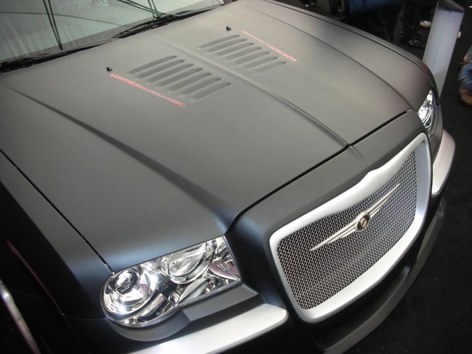 Vented matte-black hood and chrome grille of a Chrysler 300