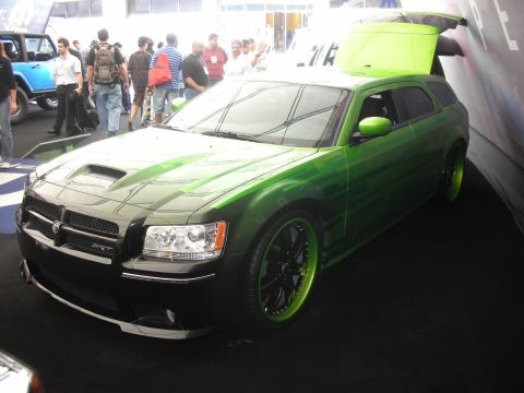 1998 Ford Crown Victoria - Green-and-black custom Dodge Magnum SRT wagon with open rear hatch and lime-lipped black wheels at a crowded show.