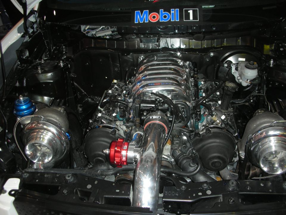 Twin-turbo V8 engine bay with chrome piping under a Mobil 1 banner