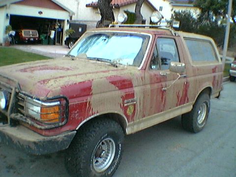 1989 Ford Bronco - This 1989 Ford Bronco is heavily covered in mud, obscuring much of its original red paint.