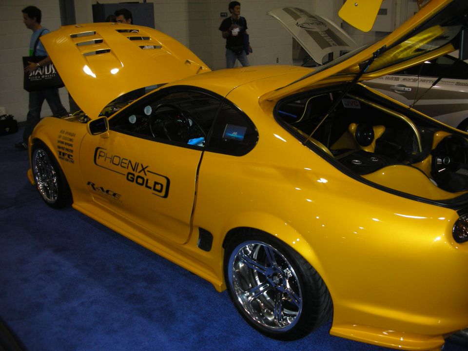 Yellow sports car with vented hood and Phoenix Gold decals, chrome wheels
