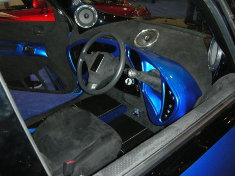 1998 Ford Crown Victoria - custom car interior with gray suede, blue metallic trim, mounted speakers and a floor-shift gear lever.