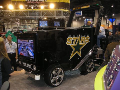 1998 Ford Crown Victoria - black 'Dallas Stars' Fan Zam promotional vehicle with mounted screens and chrome wheels at a car-audio expo.