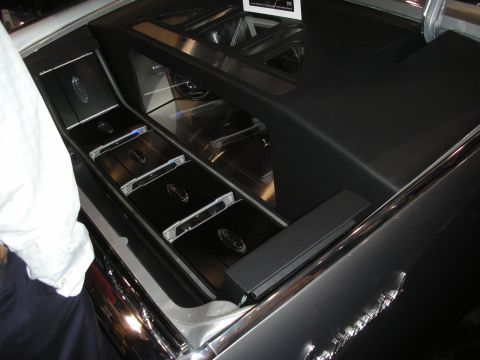 1998 Ford Crown Victoria - custom rear cargo audio install with angled mirrored panels and a row of polished chrome amplifiers.