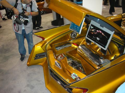 1998 Ford Crown Victoria - photographer shoots a gold custom car's open trunk fitted with an LCD screen and polished chrome equipment.