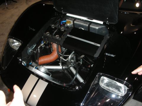 1998 Ford Crown Victoria - front compartment of a black sports car stands open, revealing an aluminum tank, hoses and a coiled copper-colored duct.