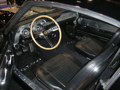 1998 Ford Crown Victoria - interior of a Shelby GT500 shows a wood-rimmed steering wheel, vintage gauges and black bucket seats with a GT500 sill plate.