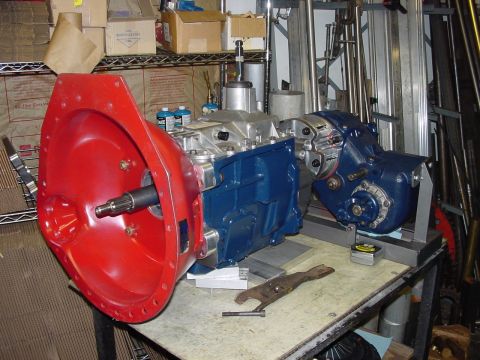 1979 Ford Bronco - A transmission and transfer case assembly is mounted on a workbench, ready for installation.
