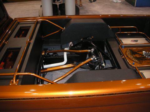 1998 Ford Crown Victoria - bed of a copper custom truck is opened to reveal a detailed black-and-copper suspension setup and engraved panels.