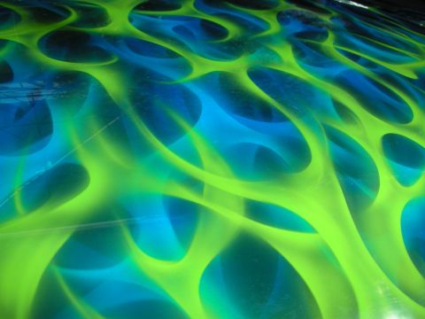 1998 Ford Crown Victoria - close-up of glossy paintwork shows swirling green and blue airbrushed flames in an abstract pattern.