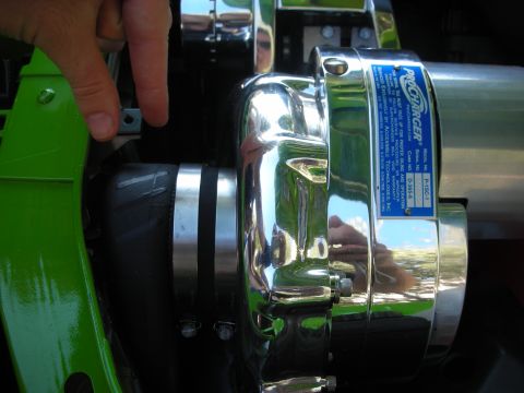 1998 Ford Crown Victoria - hand rests near a chrome ProCharger centrifugal supercharger with its identification data plate, mounted on a green-bracketed engine.