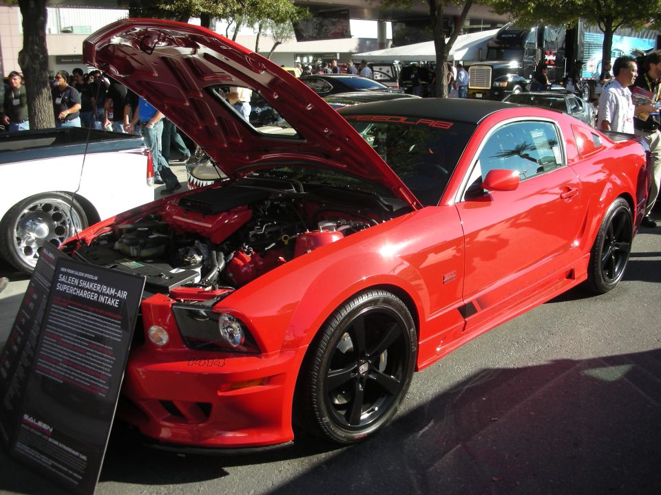 Red Saleen S281 Mustang with hood up at an outdoor car show