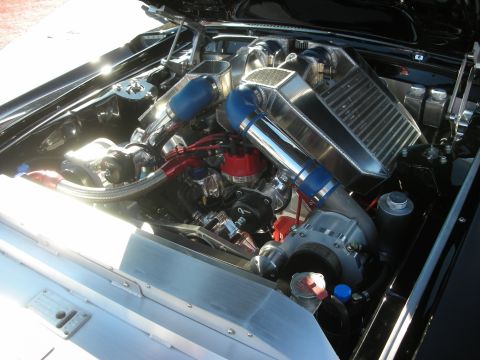 1998 Ford Crown Victoria - heavily detailed twin-turbo V8 engine bay with polished piping, blue intake tubes and a large air-to-air intercooler.