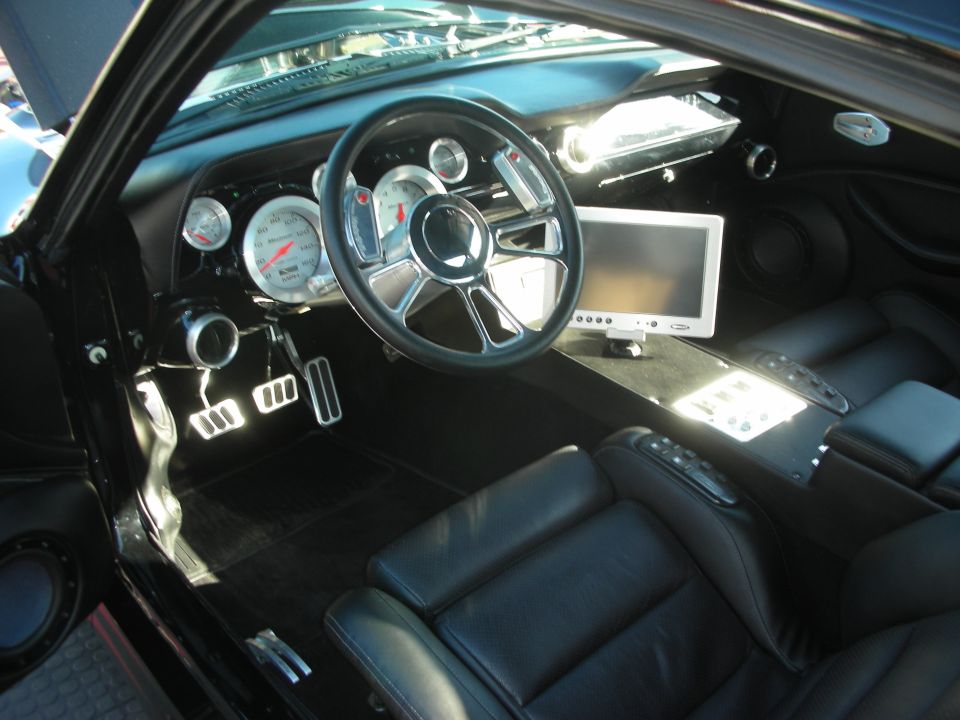 Custom car interior with billet steering wheel and dash-mounted screen