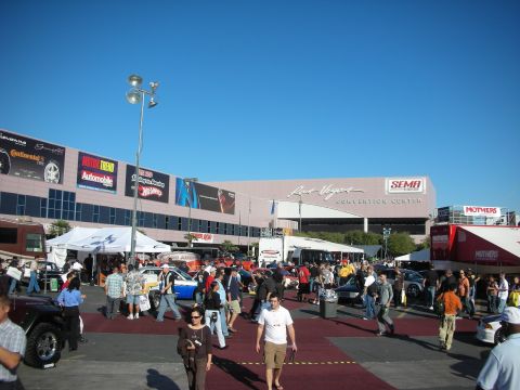 1998 Ford Crown Victoria - Crowds walk the outdoor plaza in front of the Las Vegas Convention Center under blue skies during a SEMA-style auto event.