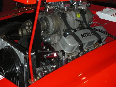 1998 Ford Crown Victoria - Polished supercharged V8 engine labeled MERLIN with a Ferrari emblem, mounted in a bright red engine bay.