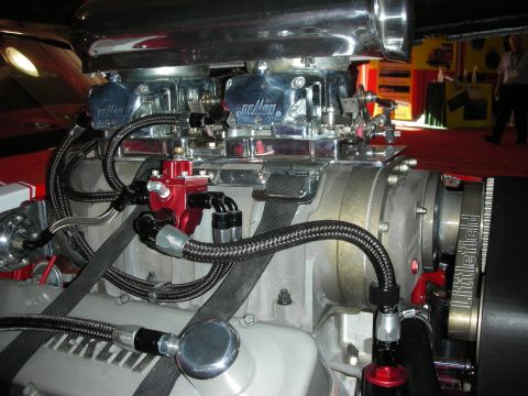 1998 Ford Crown Victoria - Twin polished Demon carburetors with braided fuel lines mounted on a Littlefield supercharger in a red engine bay.