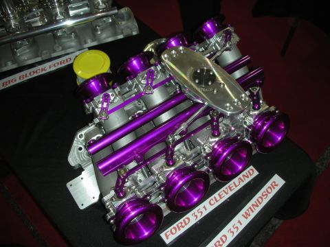 1998 Ford Crown Victoria - Purple-anodized individual-throttle-body intake for a Ford 351 Cleveland displayed beside a Big Block Ford manifold.
