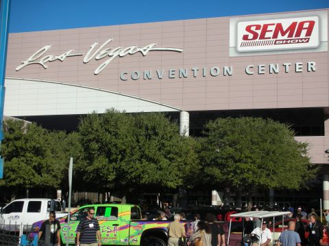 1998 Ford Crown Victoria - Exterior of the Las Vegas Convention Center with a SEMA Show banner, trees, and crowds during the event.