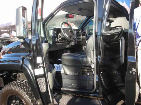 1998 Ford Crown Victoria - Open driver door of a black truck revealing a black leather interior, steering wheel, and center console.