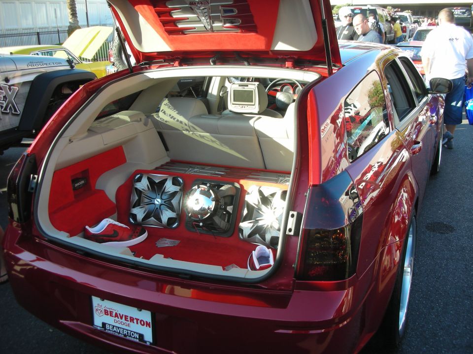 Open hatch of a maroon Dodge Magnum wagon with custom subwoofer audio install