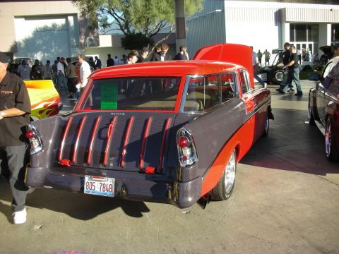 1998 Ford Crown Victoria - Custom red-and-gray two-tone 1950s Chevrolet Nomad wagon shown rear three-quarter with chrome wheels at an indoor car show.