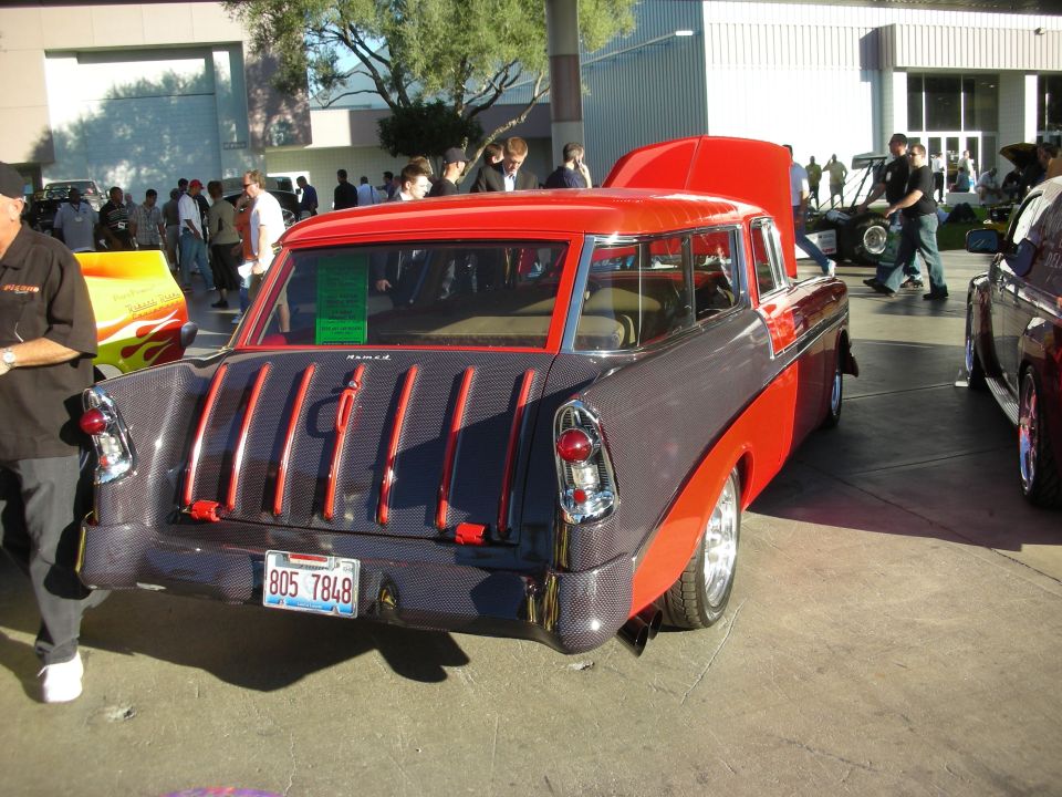Red and gray two-tone 1950s Chevy Nomad wagon rear three-quarter at show