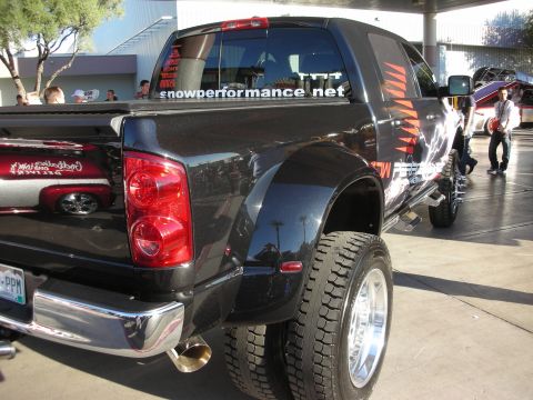 1998 Ford Crown Victoria - Lifted black Dodge dually crew-cab pickup with a snowperformance.net window decal and chrome dual rear wheels.