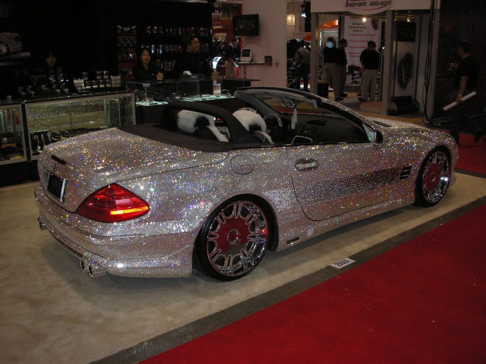 Silver convertible coated entirely in sparkling crystals on display at an indoor show
