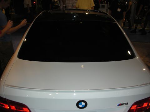 1998 Ford Crown Victoria - Rear view of a white BMW coupe showing the BMW roundel and M3 badge on the trunk under show lighting.