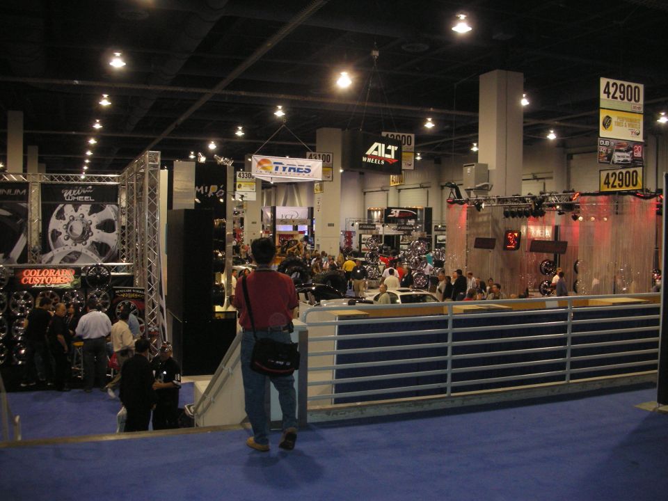 Person overlooking a busy wheel-vendor trade show floor