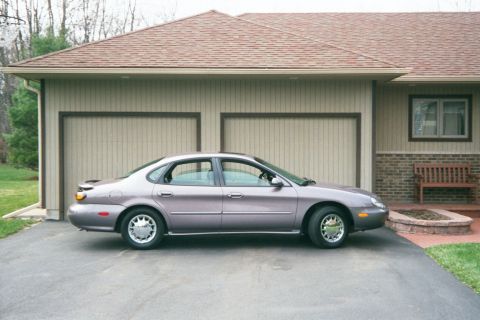 1996 Ford Taurus - A 1996 Ford Taurus sedan is parked in the driveway of a suburban home.