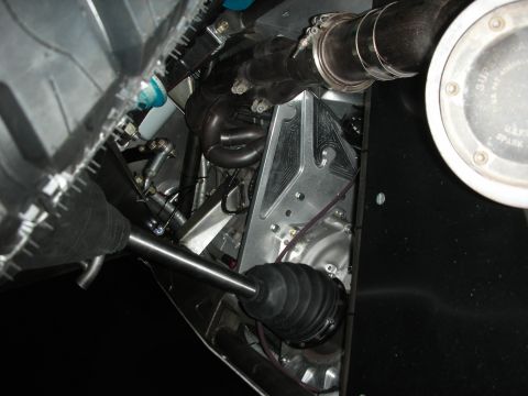1998 Ford Crown Victoria - Close-up beneath an off-road race vehicle showing the differential, CV axle boots, exhaust, and polished components.