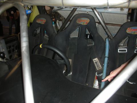 1998 Ford Crown Victoria - Cockpit of a caged race vehicle fitted with multiple black Speedway suede bucket seats and harnesses.