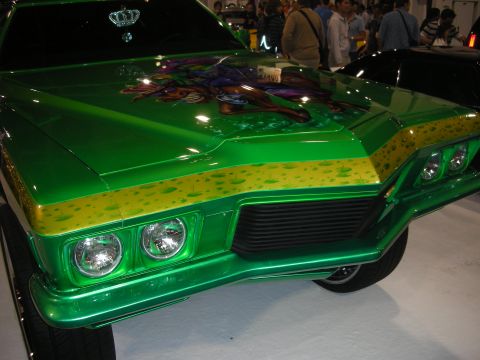 1998 Ford Crown Victoria - Front corner of a candy-green custom classic car featuring stacked headlights and an airbrushed jester mural on the hood.