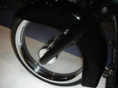 1998 Ford Crown Victoria - Close-up of a black custom motorcycle's front wheel with whitewall tire, chrome rim and black fender.