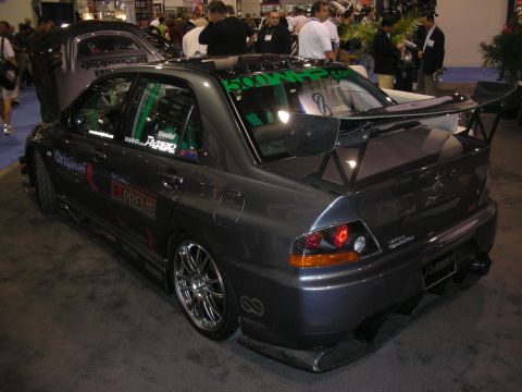 1998 Ford Crown Victoria - Black lifted Dodge Ram pickup with red-and-yellow flame graphics and polished wheels on Toyo tires at an indoor show.