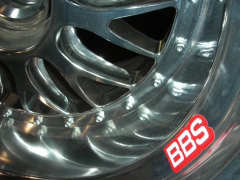 1998 Ford Crown Victoria - close-up of a polished aluminum BBS wheel reveals its turbine-style spokes, lug bolts and a red BBS logo.