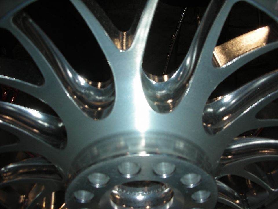 Extreme close-up of a polished multi-spoke alloy wheel center and hub