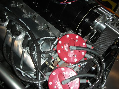 1998 Ford Crown Victoria - Close-up of two red Mallory ignition coils with braided spark plug wires and a black-finished engine block.