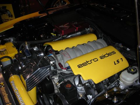 1998 Ford Crown Victoria - yellow plastic engine cover lettered Retro Rides LS7 sits atop a polished engine alongside a ProCharger supercharger.