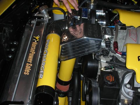 1998 Ford Crown Victoria - Close-up of a yellow and chrome ProCharger supercharger with polished covers and Muscle Power Sales branding in an engine bay.