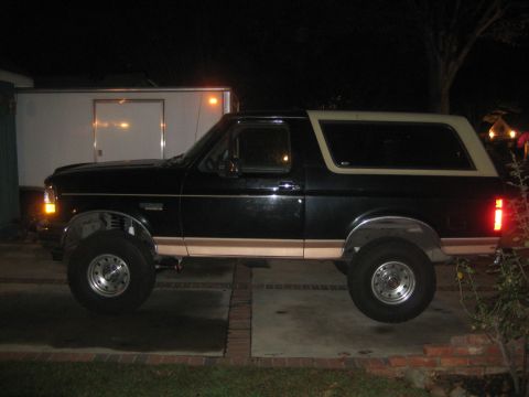 1994 Ford Bronco - This lifted 1994 Ford Bronco is seen in a driveway at night, with a trailer parked behind it.