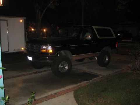 1994 Ford Bronco - Lifted 1994 Ford Bronco parked on a driveway at night.