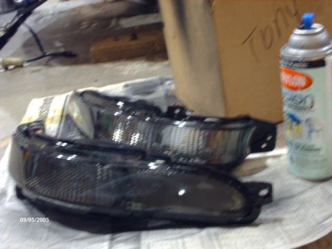 1995 Ford Probe - Aftermarket headlights sit on a cloth with a spray can nearby.