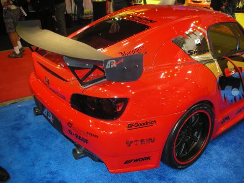 1998 Ford Crown Victoria - Rear three-quarter view of a red Honda S2000 with a tall rear wing and Spoon, Mugen, BFGoodrich, Tein, and Work decals.
