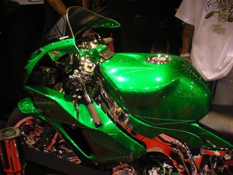 1998 Ford Crown Victoria - Detail of a custom motorcycle's deep green metalflake fuel tank with chrome handlebar controls and flame-painted lower bodywork.