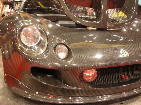 1998 Ford Crown Victoria - Detail of a carbon-fiber front clip showing a round headlight, riveted splitter and a Lotus oval badge.