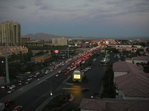 1998 Ford Crown Victoria - Dusk overhead view of heavy traffic on a multi-lane road through a desert city with distant mountains.