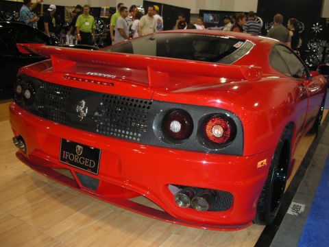 1998 Ford Crown Victoria - Rear view of a red Ferrari 360-style sports car with carbon trim and an iForged plate at an indoor show.
